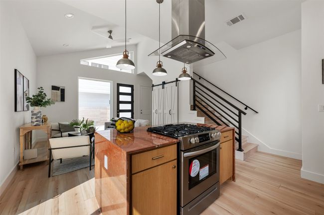 Kitchen with stainless steel gas range oven, island exhaust hood, light wood-type flooring, baseboards, and recessed​​‌​​​​‌​​‌‌​‌‌​​​‌‌​​‌‌​‌​​​​​‌ lighting | Image 10