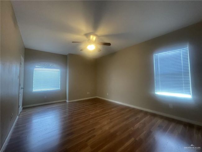Spare room featuring ceiling fan and dark wood-type flooring | Image 7