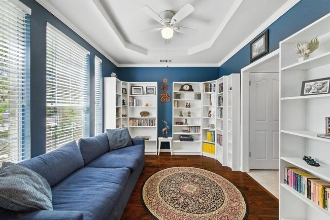 Sitting room featuring a tray ceiling, a ceiling fan, and wood finished floors | Image 13