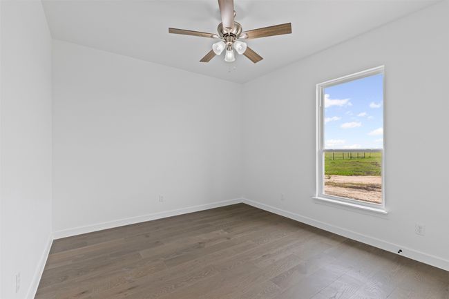 Unfurnished room with baseboards, a ceiling fan, and dark wood-style flooring | Image 34