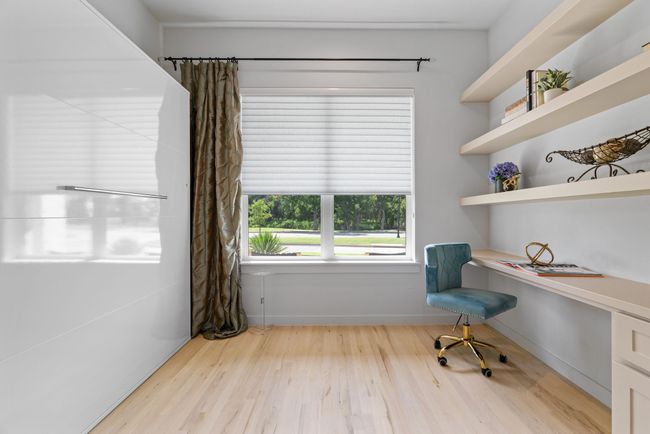 Unfurnished office with built in study area and wood finished floors | Image 23