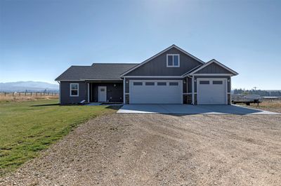 View of front of home featuring a front yard, a mountain view, and a garage | Image 1