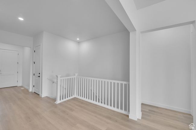 Hall featuring an upstairs landing, light wood-type flooring, recessed lighting, and baseboards | Image 8