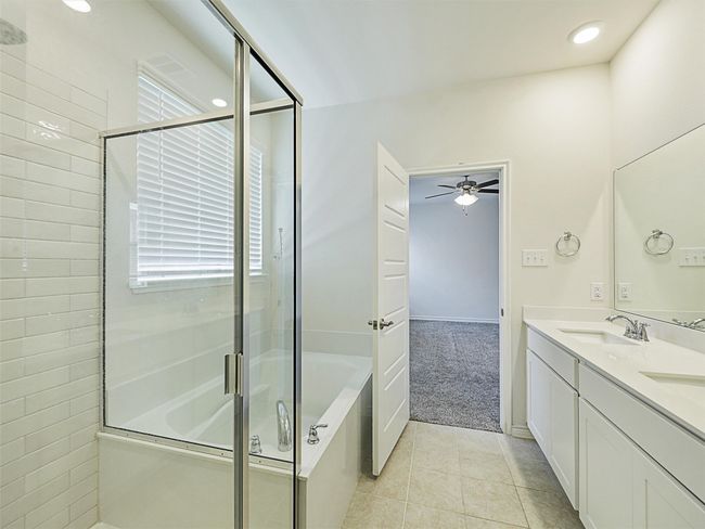 Full bath with a shower stall, double vanity, a garden tub, a ceiling fan, and tile patterned floors | Image 17