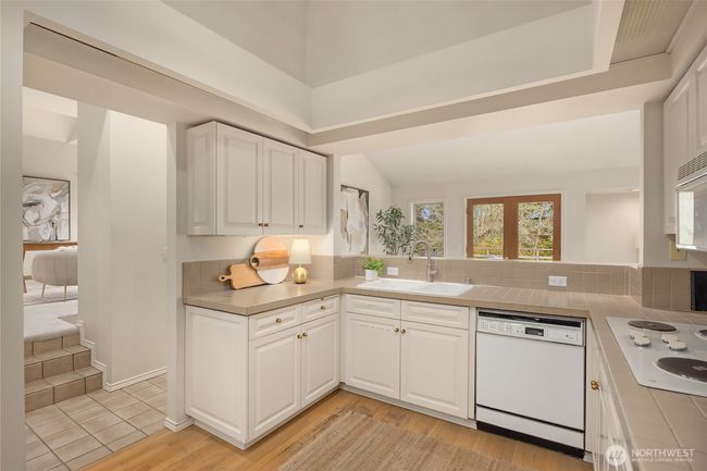 The central kitchen has tons of counter space, including extra eating space at the raised counter behind sink. | Image 20