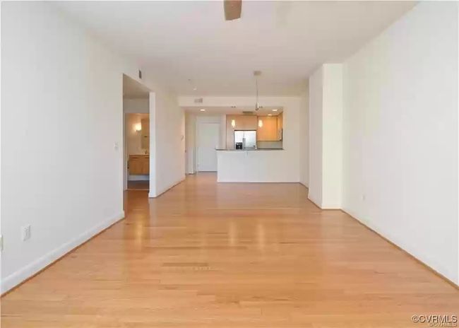 Unfurnished living room featuring light wood finished floors and baseboards | Image 10