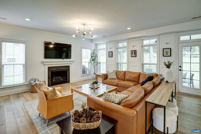 Light filled great room with modern lighting and gas fireplace. | Image 9