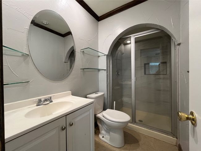 Full bathroom featuring vanity, toilet, ornamental molding, a shower stall, and tile patterned floors | Image 14