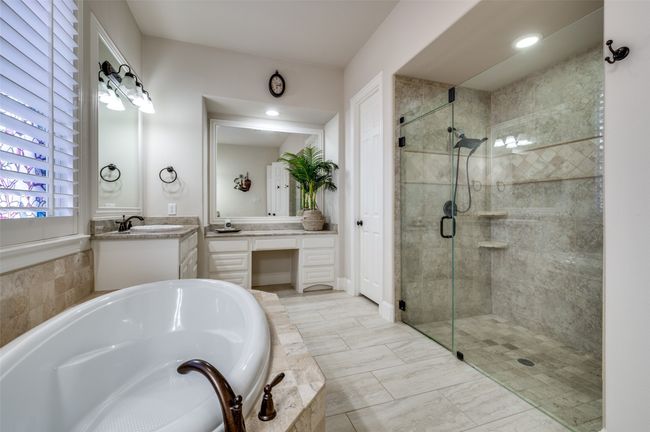 The large soaking tub is the perfect spot to unwind after a long day, while the walk-in shower, featuring frameless glass and upgraded tile work, adds a touch of luxury. | Image 22