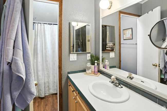 Full bathroom with a textured wall, wood finished floors, and vanity | Image 13