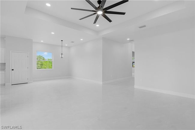 Tiled empty room featuring ceiling fan and a raised ceiling | Image 17