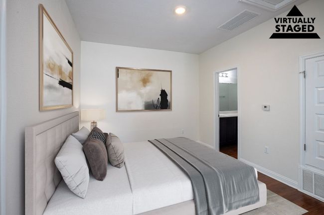 Bedroom featuring ensuite bathroom, dark wood-style floors, baseboards, and visible vents | Image 28