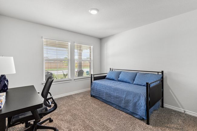 Carpeted bedroom featuring baseboards and an office area | Image 27