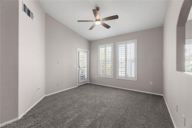 Unfurnished room featuring a ceiling fan, visible vents, vaulted ceiling, and carpet | Image 11