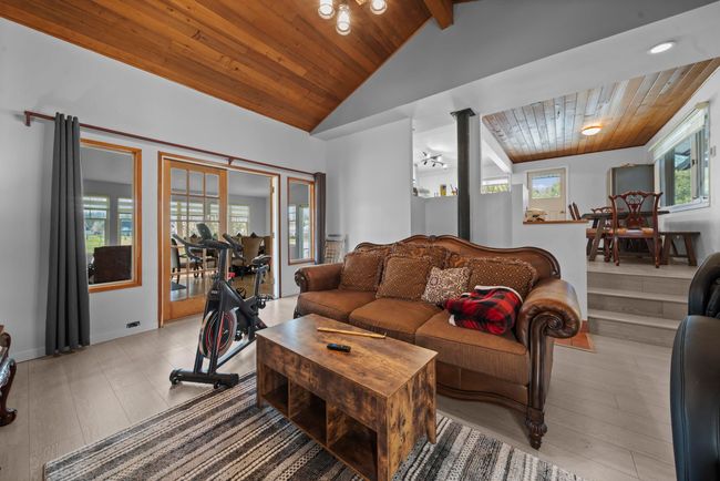 Living room featuring wood ceiling, lofted ceiling with beams, and decorative columns | Image 7