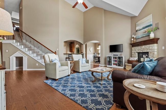 Soaring ceilings, rich wood floors, and a wall of sun-filled windows invite both grandeur and comfort into this elegant living space. | Image 6