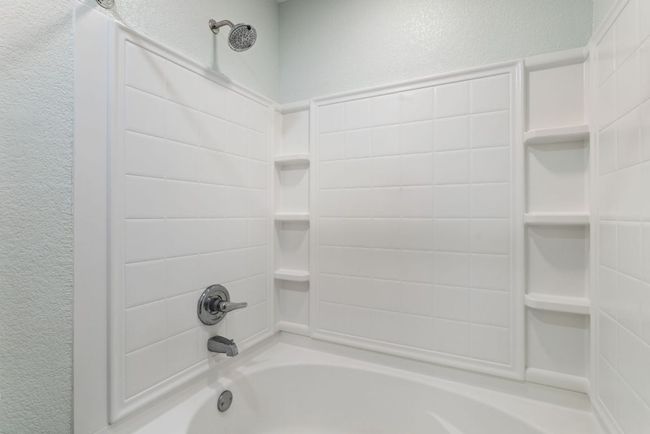 Full bathroom featuring a textured wall and bathtub / shower combination | Image 21