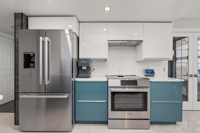 Kitchen with white cabinets, stainless steel appliances, blue cabinets, and ventilation hood | Image 17