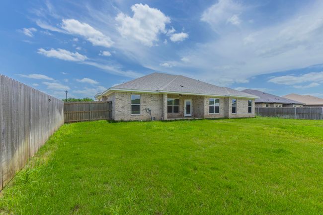 Rear view of house featuring a fenced backyard and brick siding | Image 23