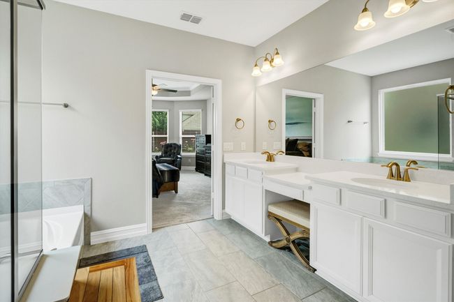 Primary bathroom features tile floors, dual sinks, and gold fixtures. | Image 21