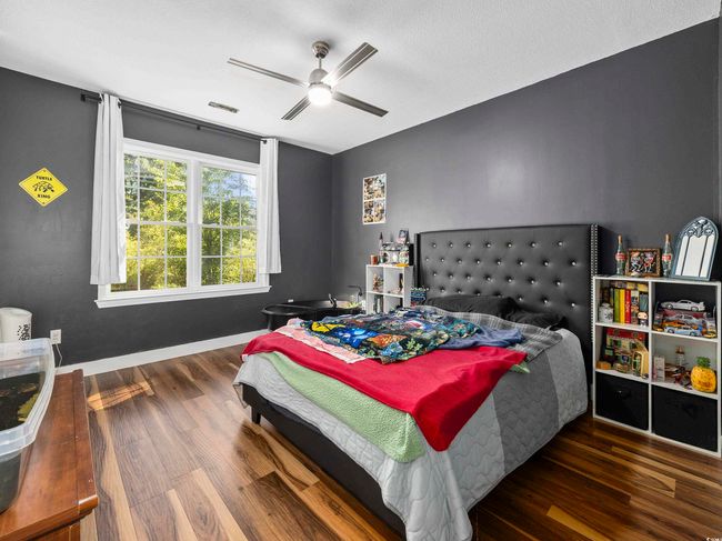 Bedroom featuring baseboards, ceiling fan, visible vents, and wood finished floors | Image 18