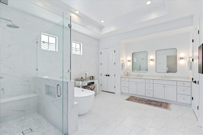 Bathroom featuring a marble finish shower, double vanity, a soaking tub, marble look tile flooring, and recessed lighting | Image 18