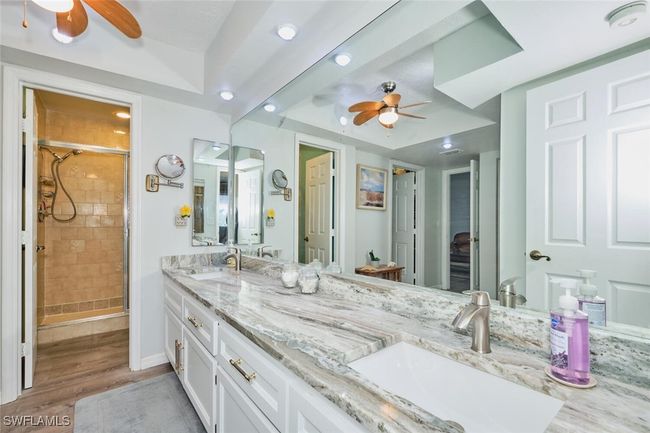 Bathroom with a ceiling fan, double vanity, a stall shower, wood finished floors, and recessed lighting | Image 23