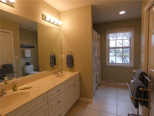 The main/guest bath is located on the upper level and features double vanities and a huge linen closet. | Image 35
