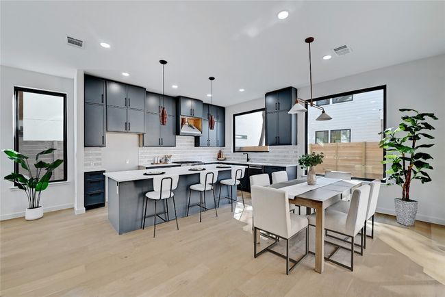 Kitchen with decorative light fixtures, a center island, light hardwood / wood-style flooring, and tasteful backsplash | Image 8