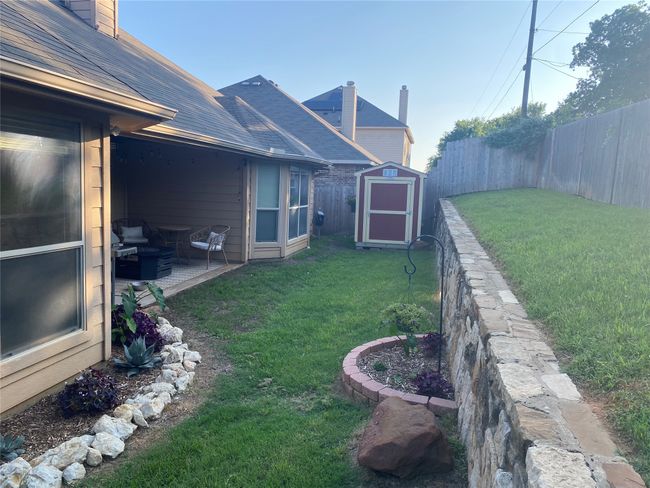 View of yard featuring a fenced backyard, an outbuilding, a patio area, and a shed | Image 5