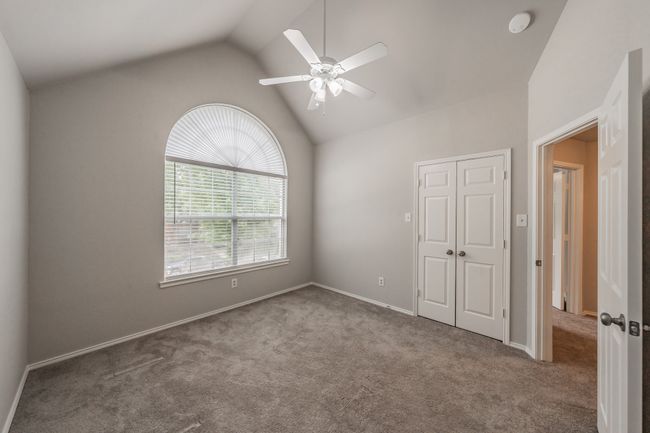 Secondary bedroom on the front of the house with vaulted ceilings and ceiling fan. | Image 30