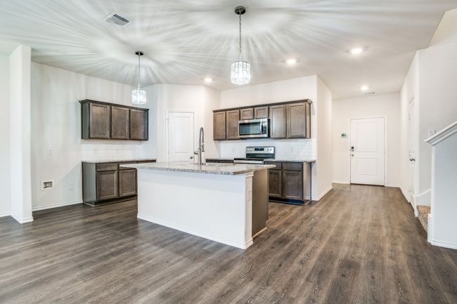Kitchen featuring appliances with stainless steel finishes, dark wood-type flooring, decorative backsplash, recessed lighting, and pendant lighting | Image 4