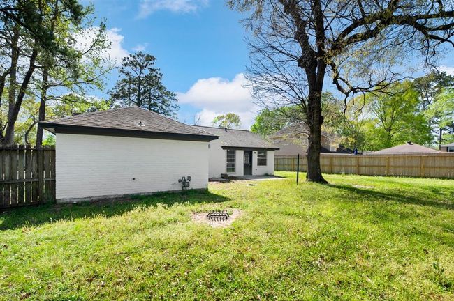 The generously sized backyard features a spacious patio, perfect for outdoor dining, entertaining, or simply unwinding. With plenty of room to enjoy, this outdoor space is ideal for relaxation and gatherings. | Image 33