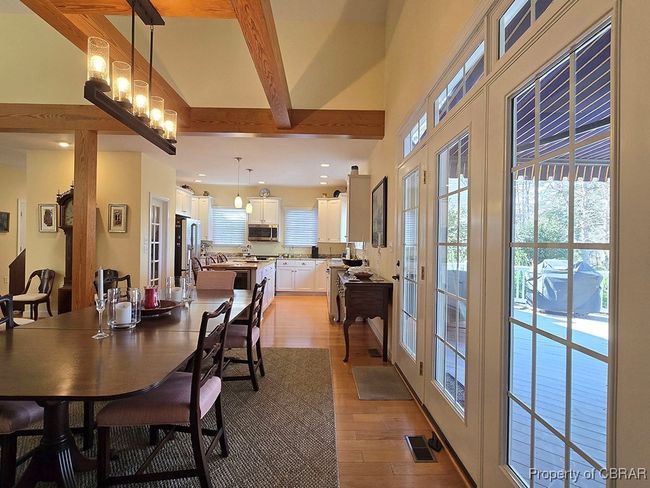 Dining room featuring beam ceiling, a towering ceiling, visible vents, and light wood-type flooring | Image 19