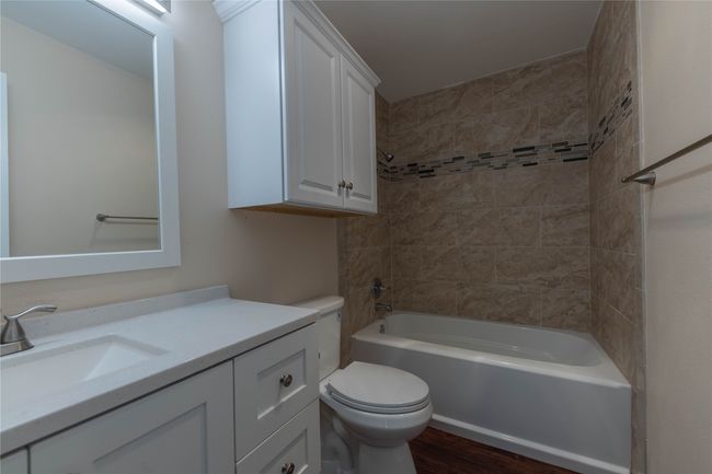 Bathroom featuring toilet, vanity, wood finished floors, and shower combination | Image 30