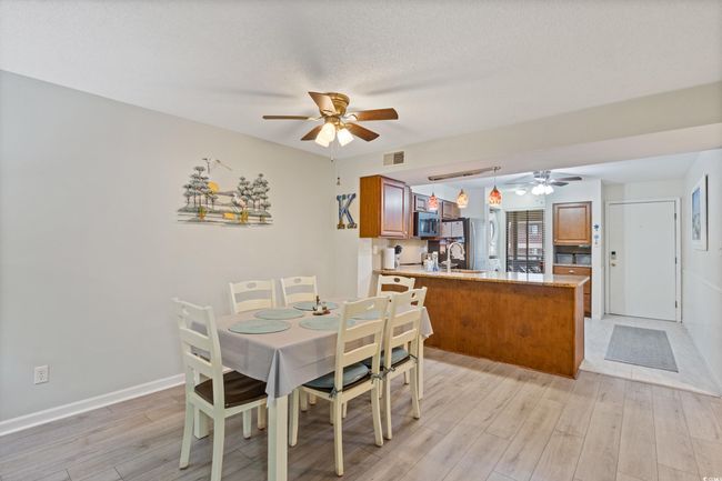 Dining space with visible vents, a ceiling fan, light wood-style flooring, and baseboards | Image 12