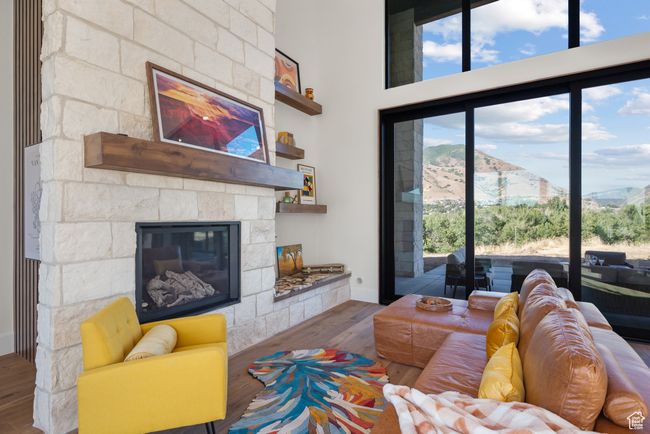 Living area featuring wood finished floors, a stone fireplace, and a mountain view | Image 11