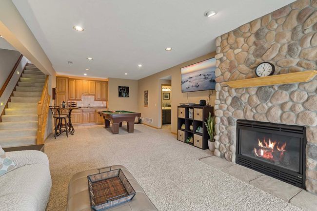 Lower level family room with stone, gas fireplace and wet bar. | Image 20