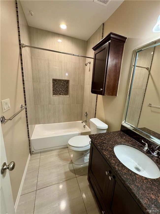 Full bathroom featuring toilet, tile patterned flooring, tub / shower combination, and vanity | Image 10