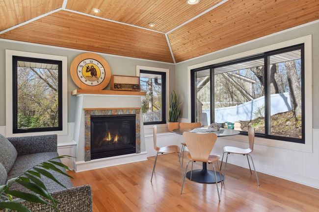 Cozy gas fireplace, hardwood floors, tray ceiling with wood accents, and plenty of windows to let the natural light in | Image 18