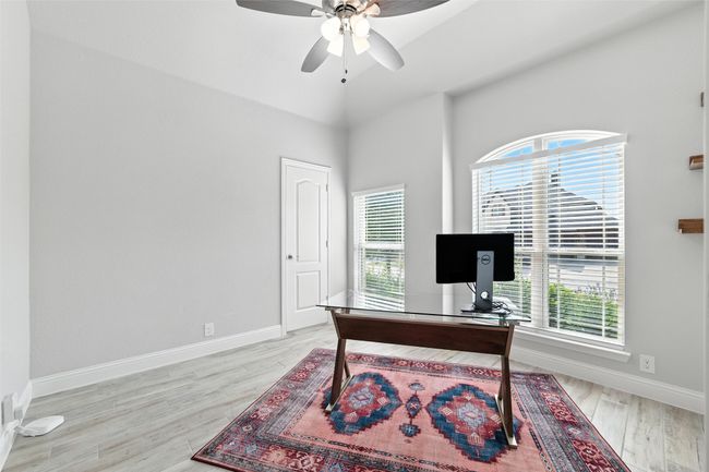 Office area with healthy amount of natural light, ceiling fan, wood finished floors, and a towering ceiling | Image 31