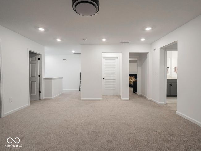 basement with light carpet, baseboards, visible vents, and recessed lighting | Image 31