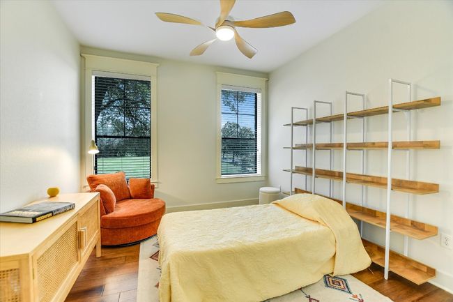 Bedroom with wood finished floors and ceiling fan. Great for guests or could be used for a home office. | Image 15