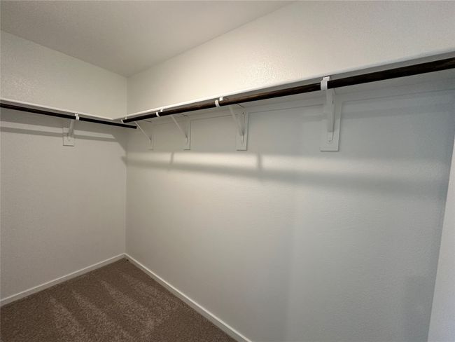 Spacious closet with dark colored carpet | Image 12