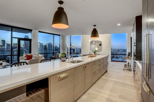 Stunning open kitchen featuring built-in Miele appliances, a gas cooktop, wine fridge, all overlooking the downtown views. | Image 13