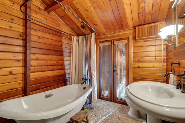 Full bath with a freestanding tub, wood ceiling, lofted ceiling, and log walls | Image 18