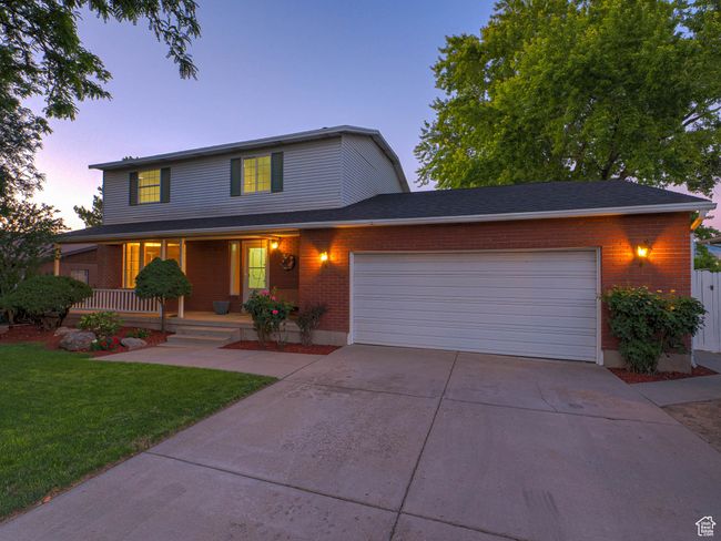 Traditional home with a garage, a porch, concrete driveway, and a front lawn | Image 7