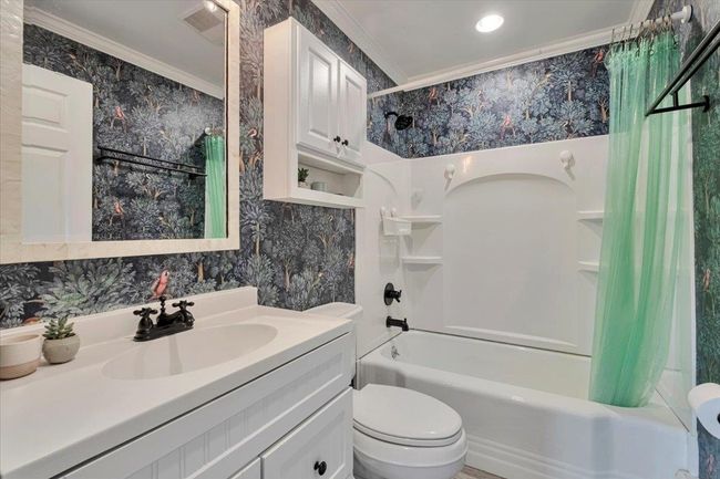 Full bathroom with wallpapered walls, crown molding, toilet, and shower / bath combo with shower curtain | Image 11