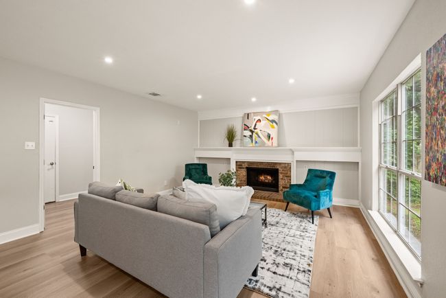 The brick fireplace adds warmth and character. The white built-in shelves and paneling provide a classic yet updated look. | Image 18
