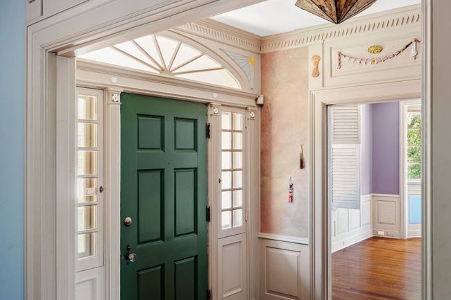 Entryway with a decorative wall, wainscoting, and wood finished floors | Image 8